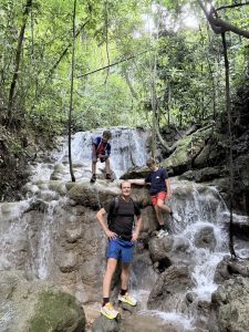 A father and his two sons posing in front of a waterfall in Khao Sok.